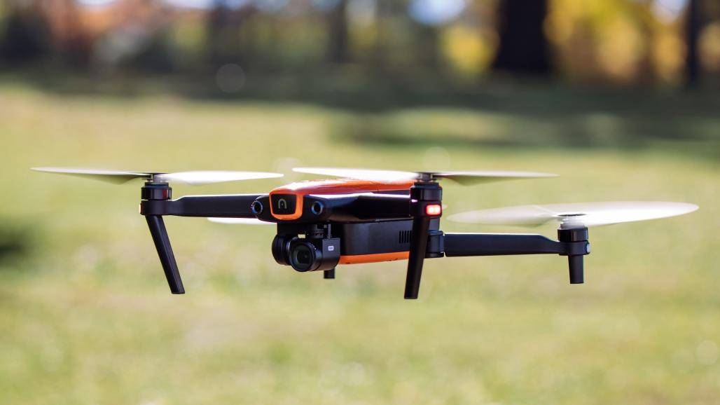 drone naranja y negro volando sobre hierba